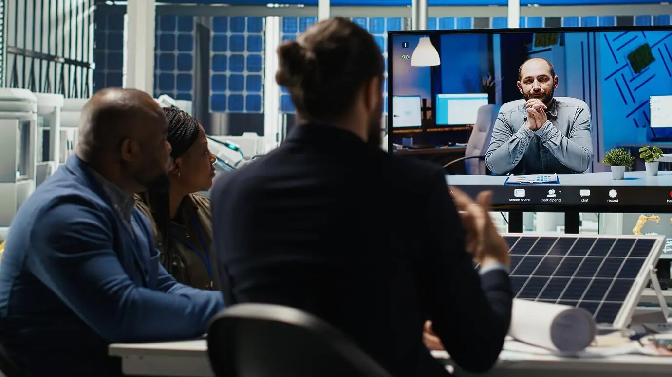 Forscher einer Photovoltaikanlage führen einen Videoanruf durch, um die Energieproduktion zu optimieren.