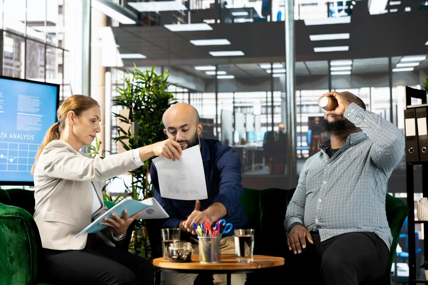 Buchhalter sehen sich im Büro Dokumente mit Umsatzzahlen an.